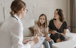 A mother and daughter meeting with a family doctor during a medical appointment in Boise, Idaho