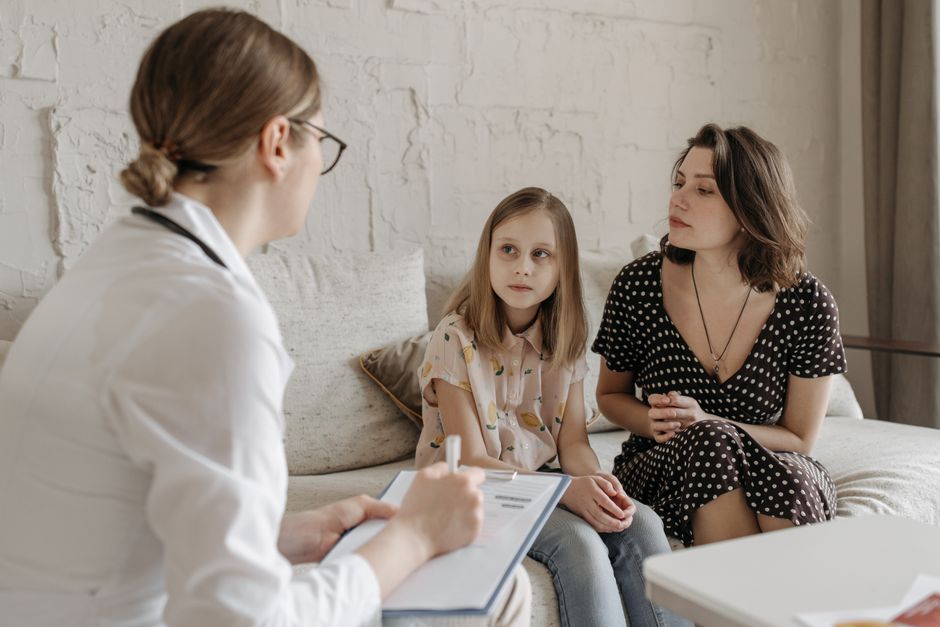 A mother and daughter meeting with a family doctor during a medical appointment in Boise, Idaho