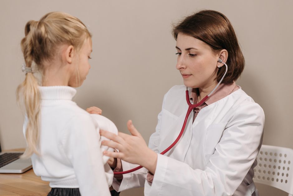 When Summer Sickness Is More Than Just a Cold Family doctor in Boise uses stethoscope to examine young girl during a sick visit at a primary care clinic